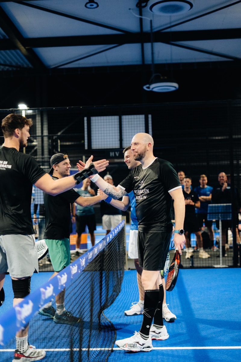 Spelers geven elkaar een hand na een wedstrijd tijdens de FrontRow Business Padel Cup