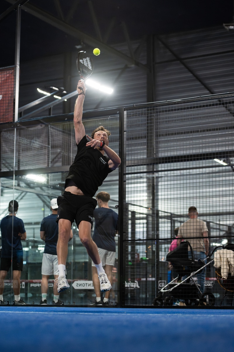 Speler maakt een smash tijdens een intens rallymoment bij de FrontRow Business Padel Cup