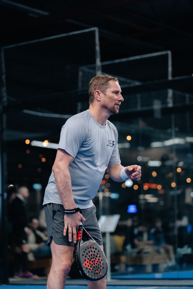 Speler staat klaar op de padelbaan tijdens FrontRow Business Padel Cups met focus en wedstrijdspanning